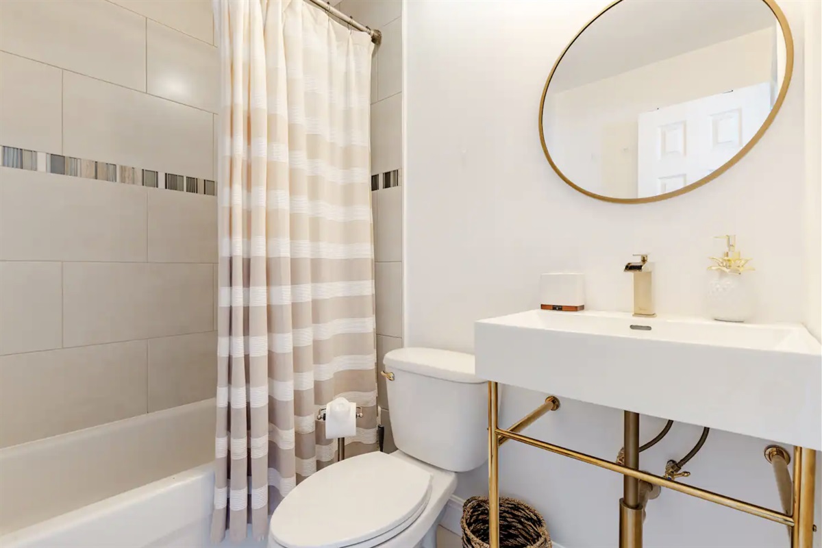 Second full bathroom is equipped with expanded towel rack with stylish sink and mirror.