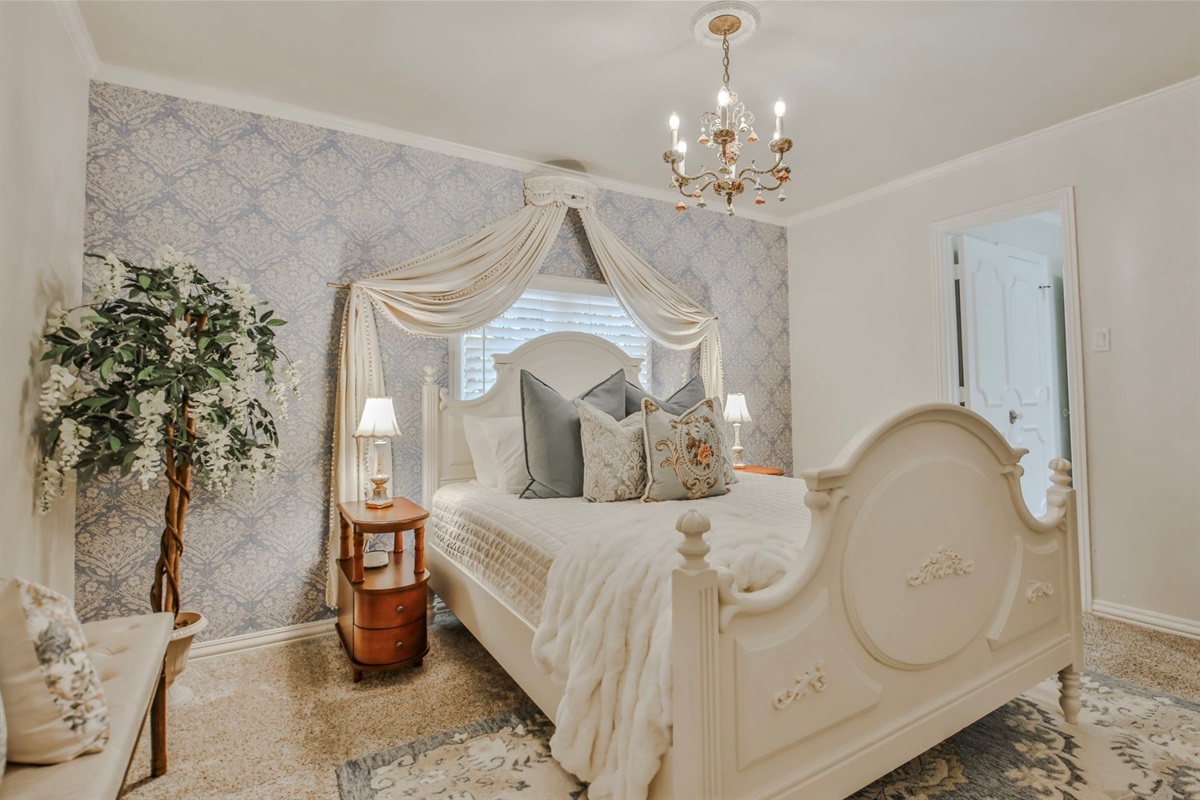 The Daphne Room: Where chandeliers twinkle and firelight dances softly—this upstairs haven offers a queen bed, smart TV, and a shared Jack and Jill bath.