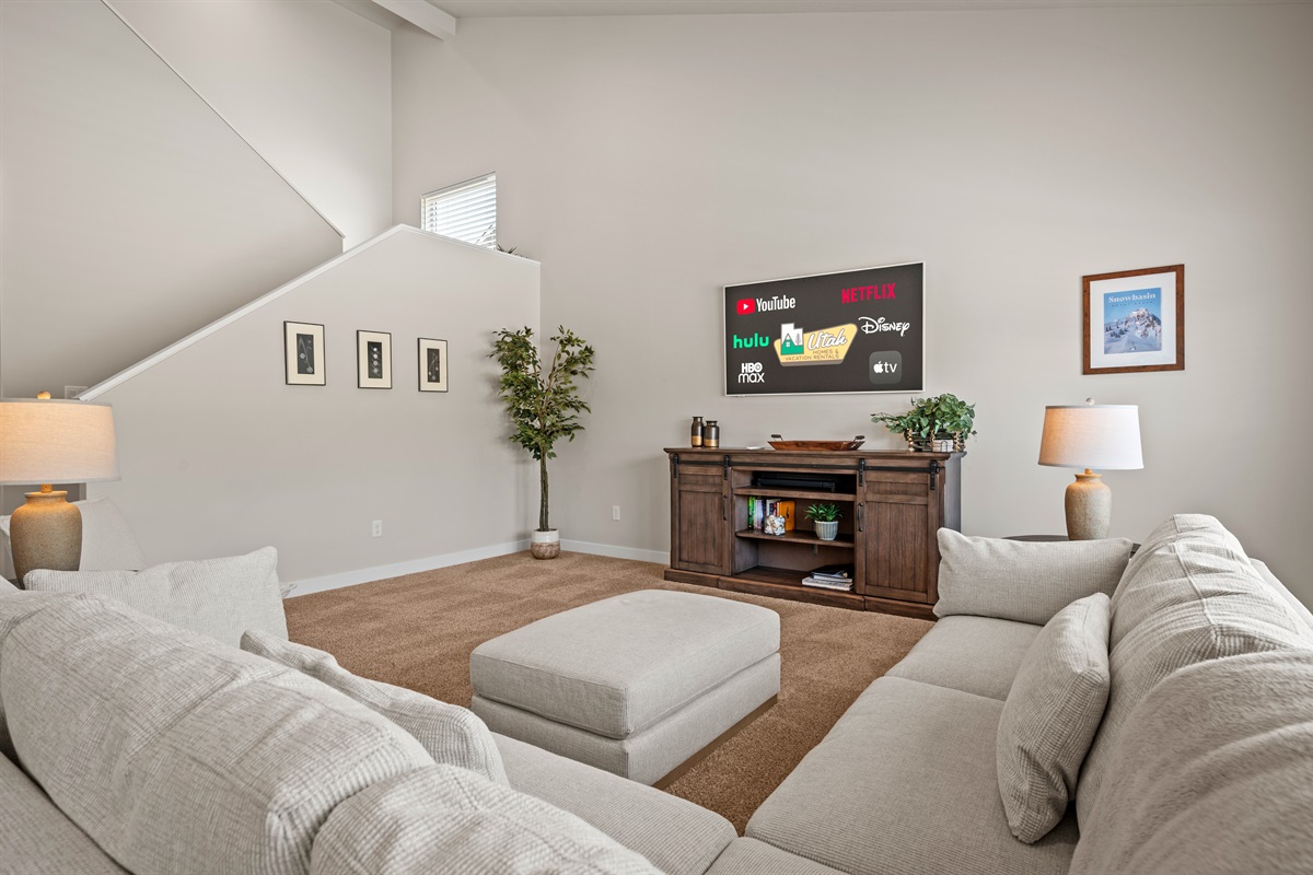 Bright and airy, this living room boasts high ceilings, cozy furnishings, and a welcoming atmosphere that makes you feel right at home.