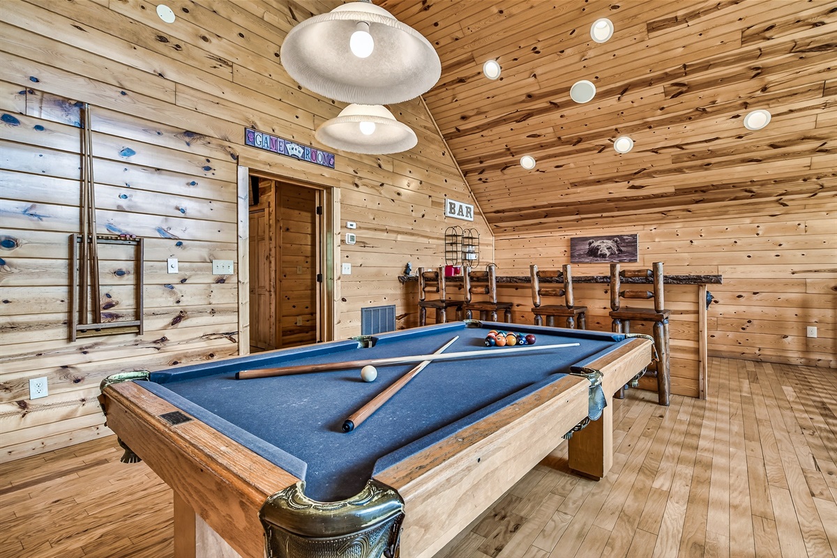 Pool table with a bar area and mini fridge 