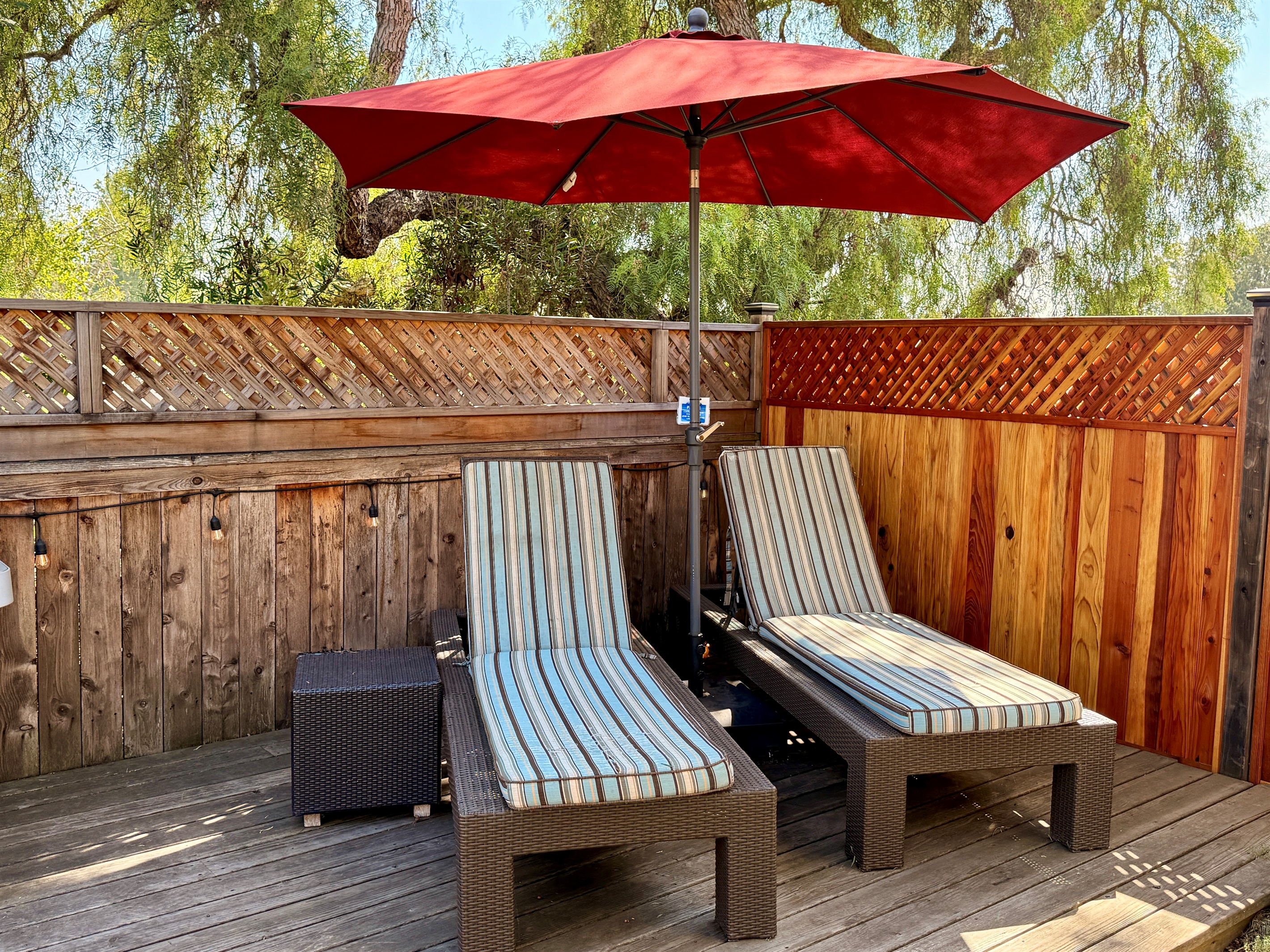 Outdoor deck includes privacy fence, BBQ with tools and propane, 2 chaise lounge chairs, a teak dining table with 4 chairs, and 2 camping rocker chairs (stored in garage).