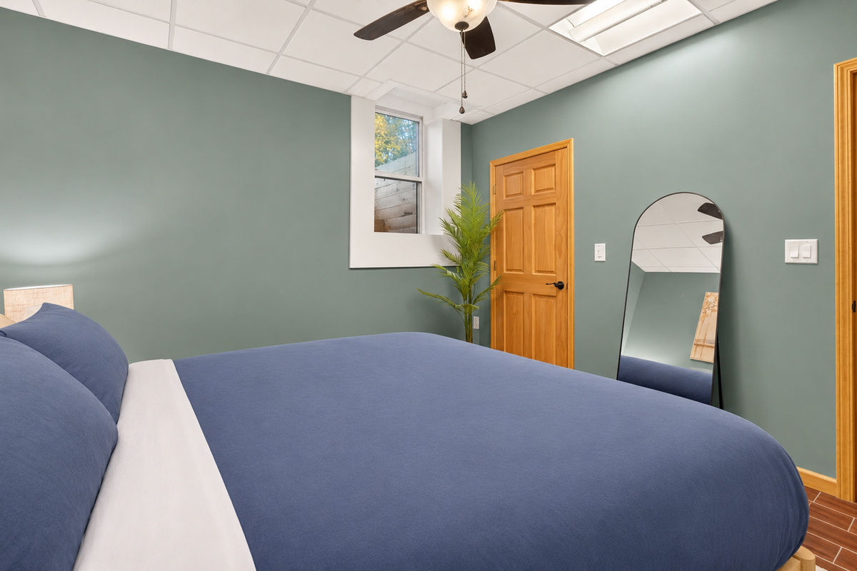 Bedroom with ceiling fan and full-length mirror