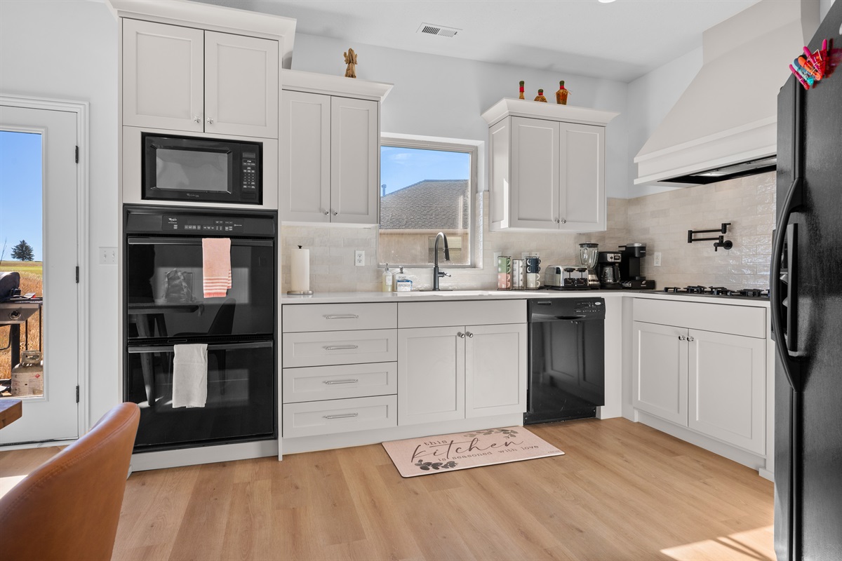 This well-equipped kitchen features a gas stove, large kettle, dishwasher, microwave, and double oven.