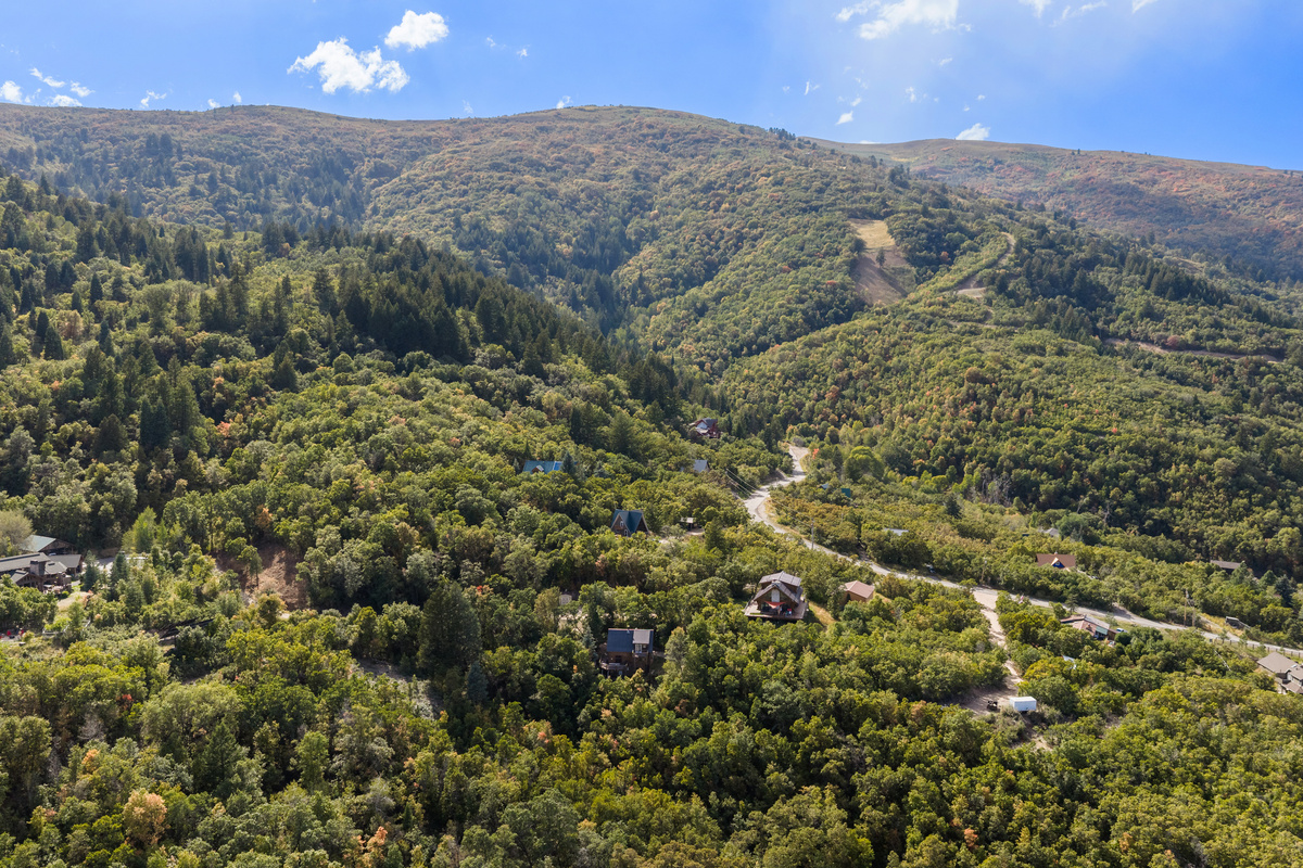 Aerial perspective highlighting the winding roads and forested mountain landscape nearby.