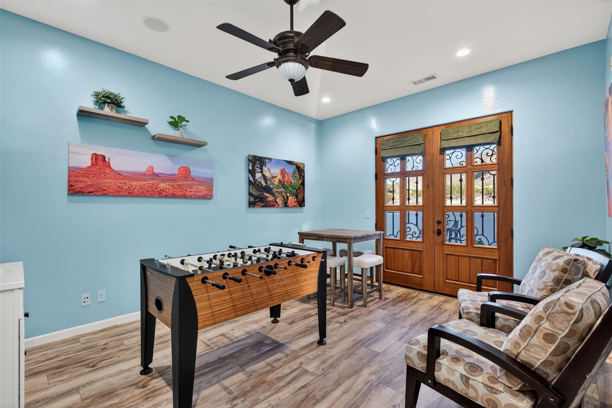 Dedicated game room with foosball table and lounge seating offers fun indoor entertainment for all ages