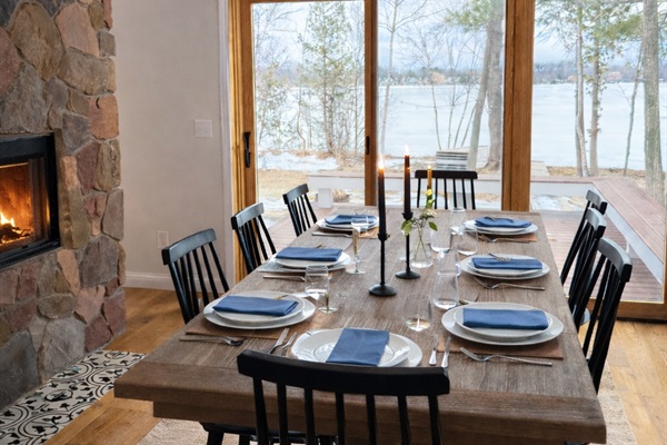 Set the table, light the candles, and settle in. Framed by the warmth of the stone fireplace and serene lake views, this dining space invites guests to savor long dinners, local wine, and meaningful time together.