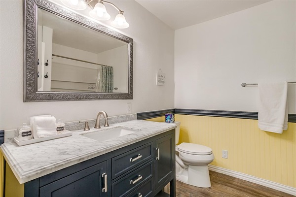 Spacious full bathroom with shower/tub combo and modern vanity — clean, bright, and well stocked.