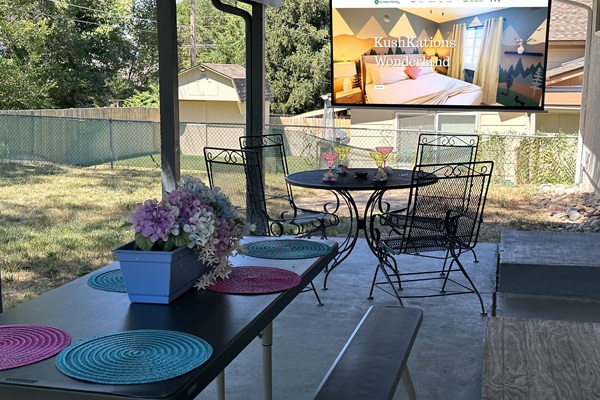 Your private backyard escape with cozy seating, a dining table, and a projector for ultimate relaxation!