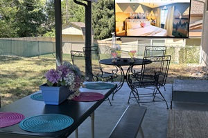 Your private backyard escape with cozy seating, a dining table, and a projector for ultimate relaxation!