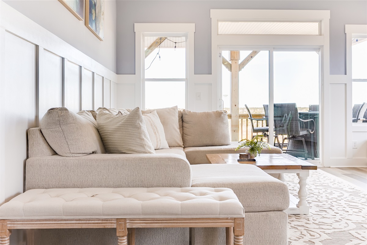 A cozy angle of the living area highlights the inviting sectional and natural light that fills the space throughout the day