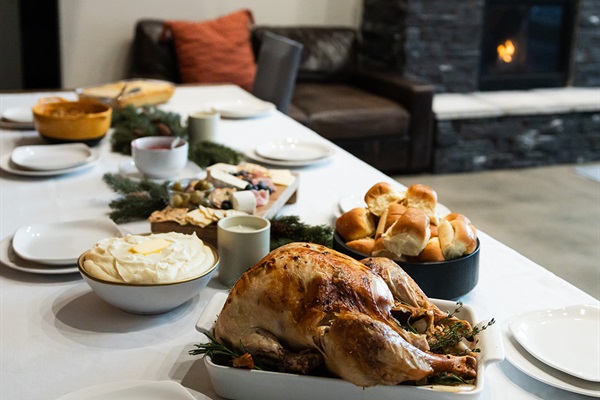 Cozy dining next to a warm stone fireplace.