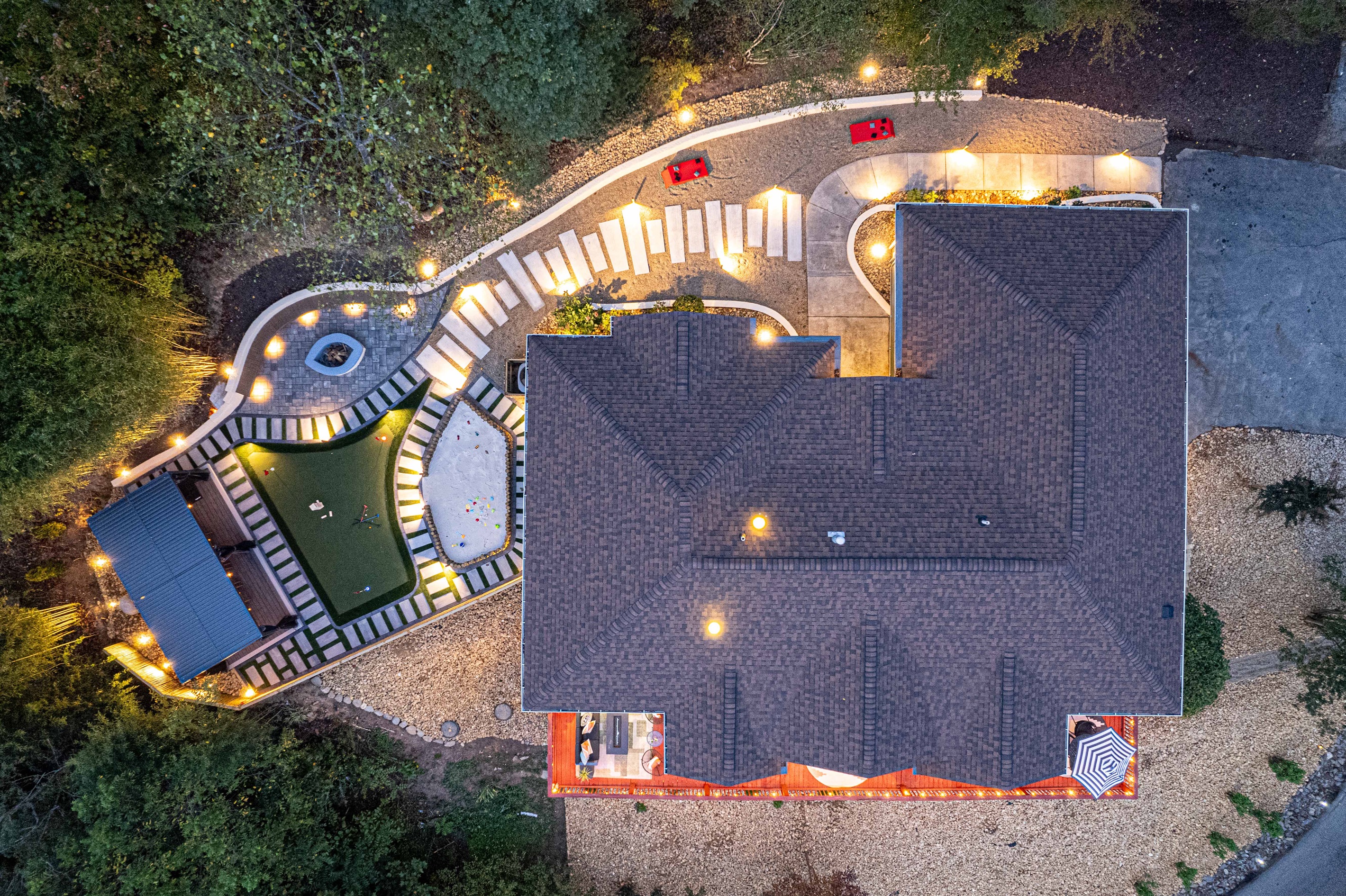 An aerial view of your ultimate escape—this stunning landscape features perfectly lit walkways, lush greens, and a cozy fire pit area for your evening gatherings.