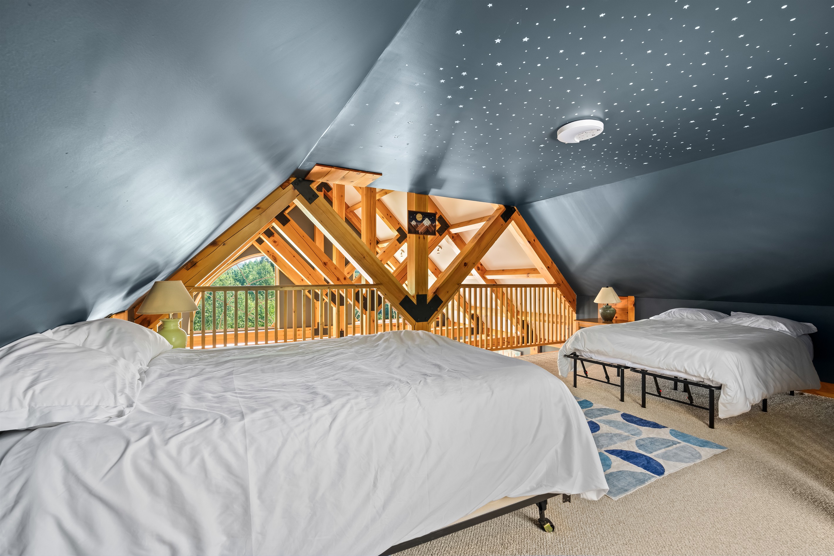 Drift off beneath a ceiling of stars in the cozy loft where sleep feels magical after full group days.