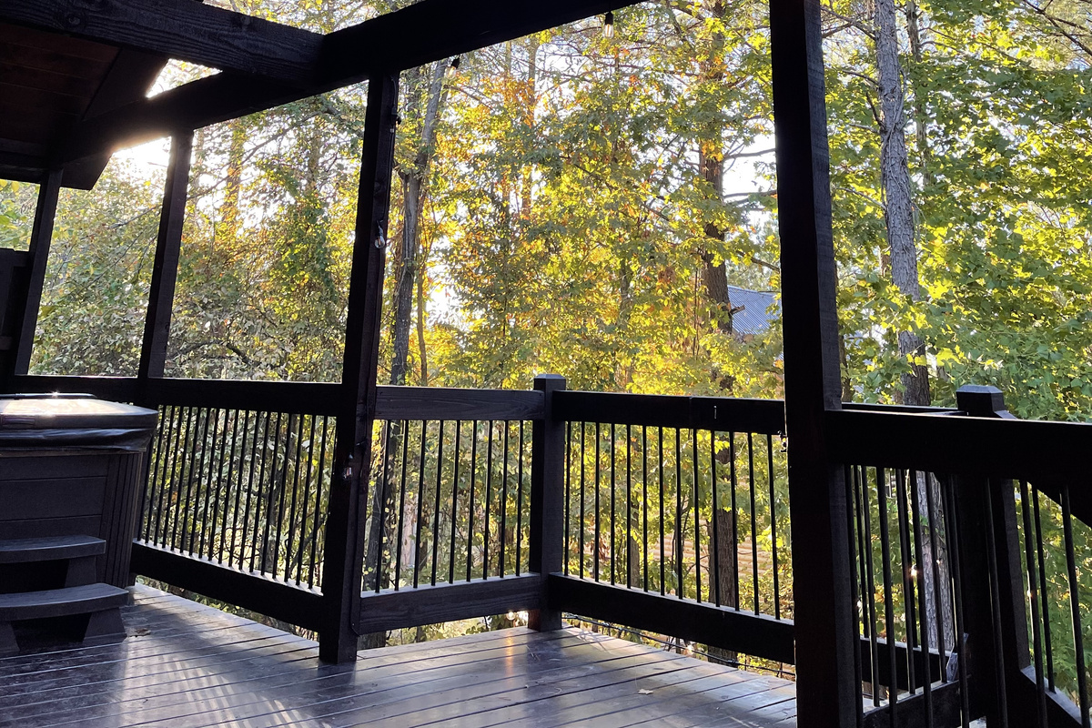 Large open deck with steps leading down to the fire pit area and a view of the Hot Tub.