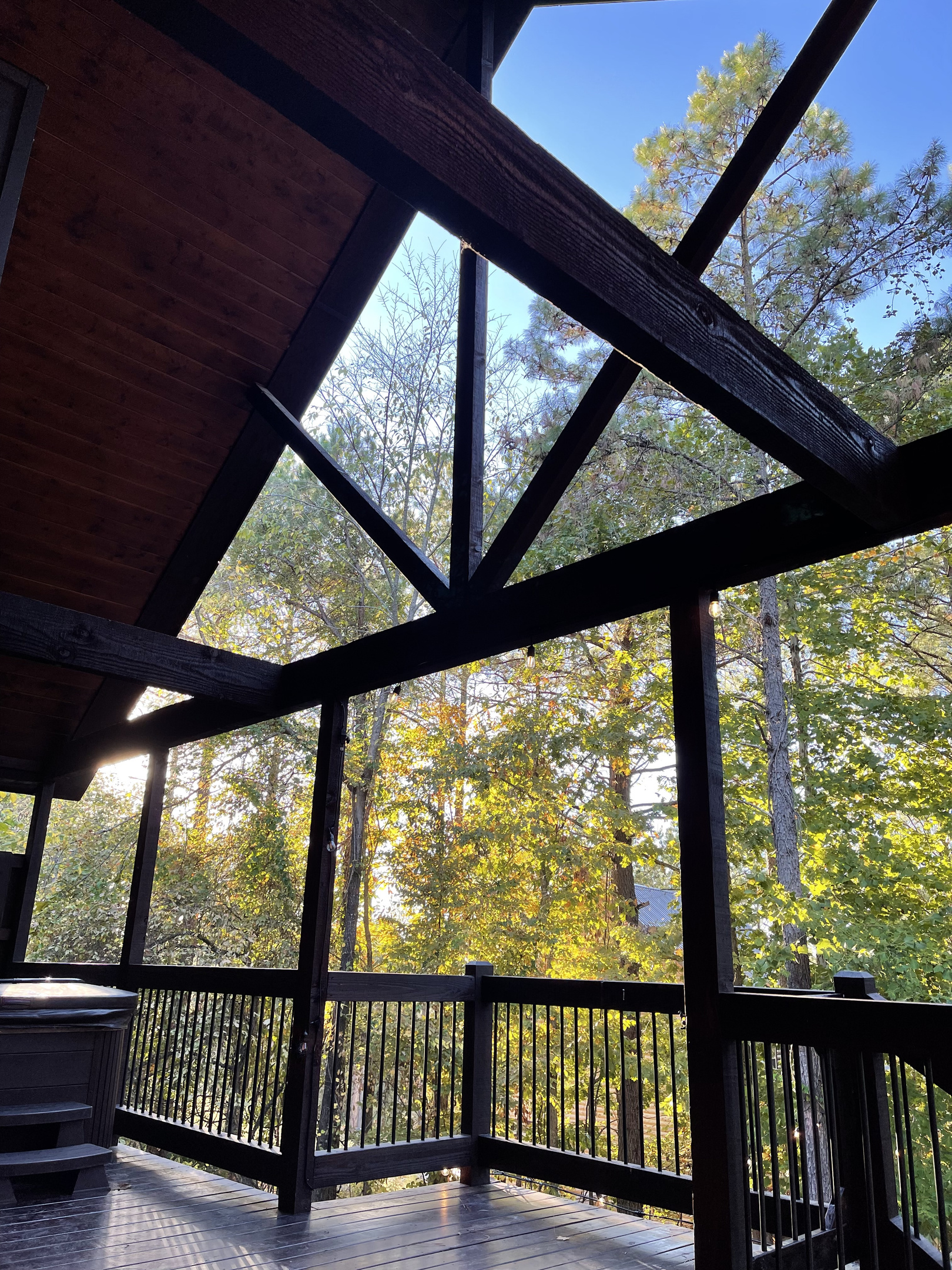 Large open deck with steps leading down to the fire pit area and a view of the Hot Tub.