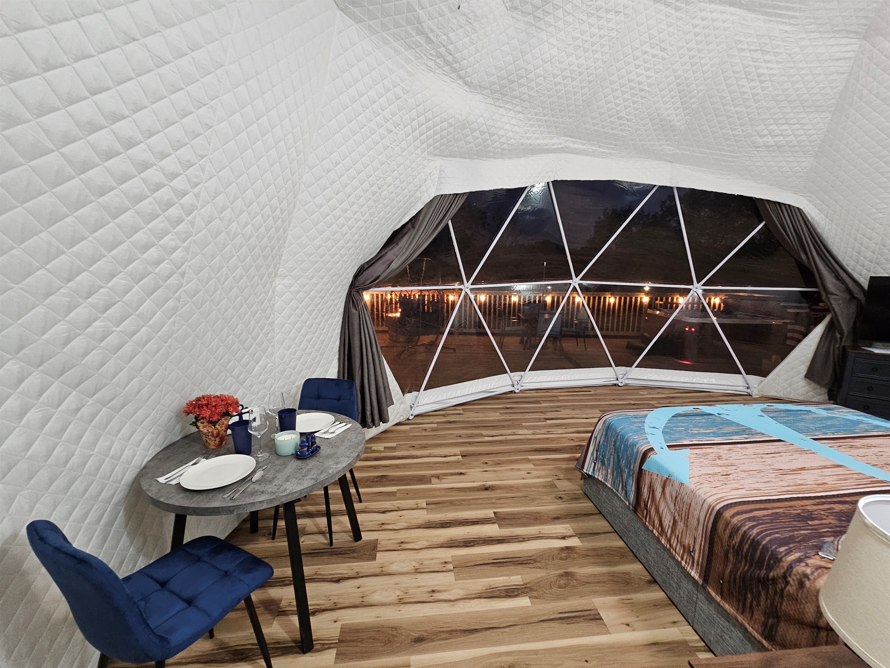 Intimate dining for two with a stunning nighttime view of the glowing deck and lakeside backdrop