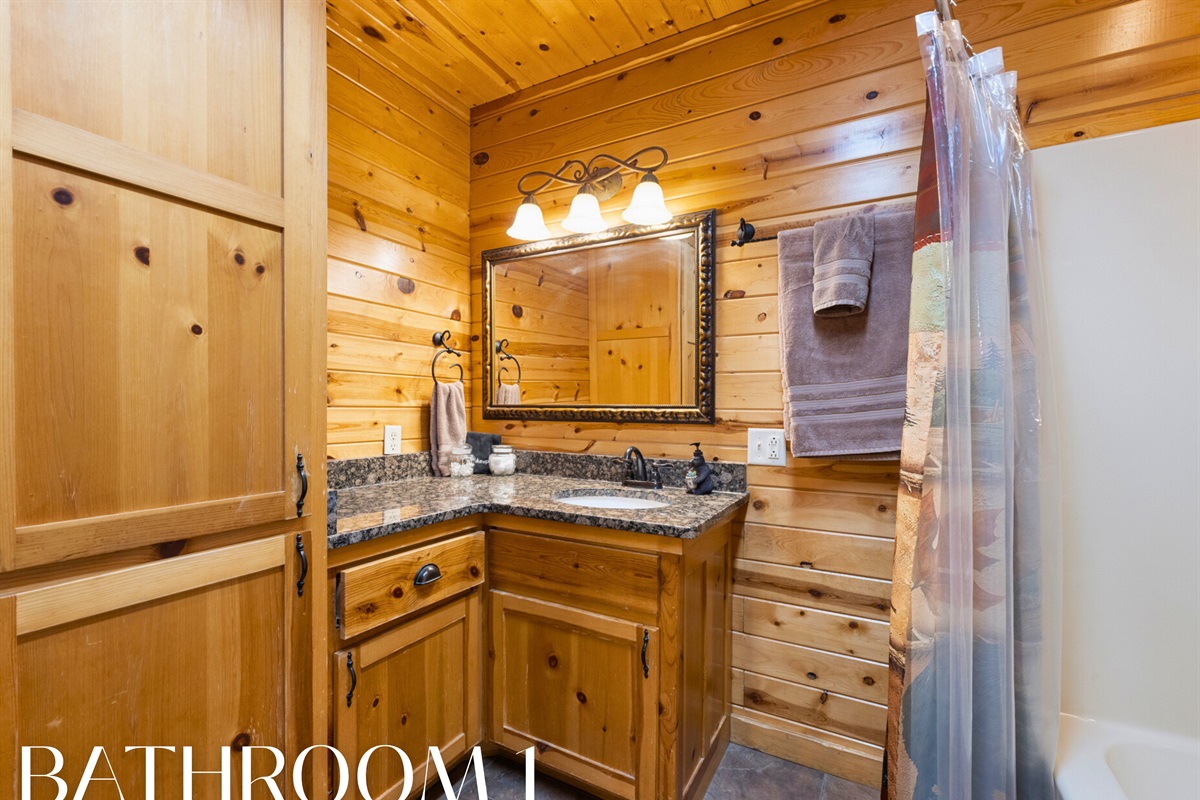 Bathroom 1 with rustic vanity and shower/tub combo