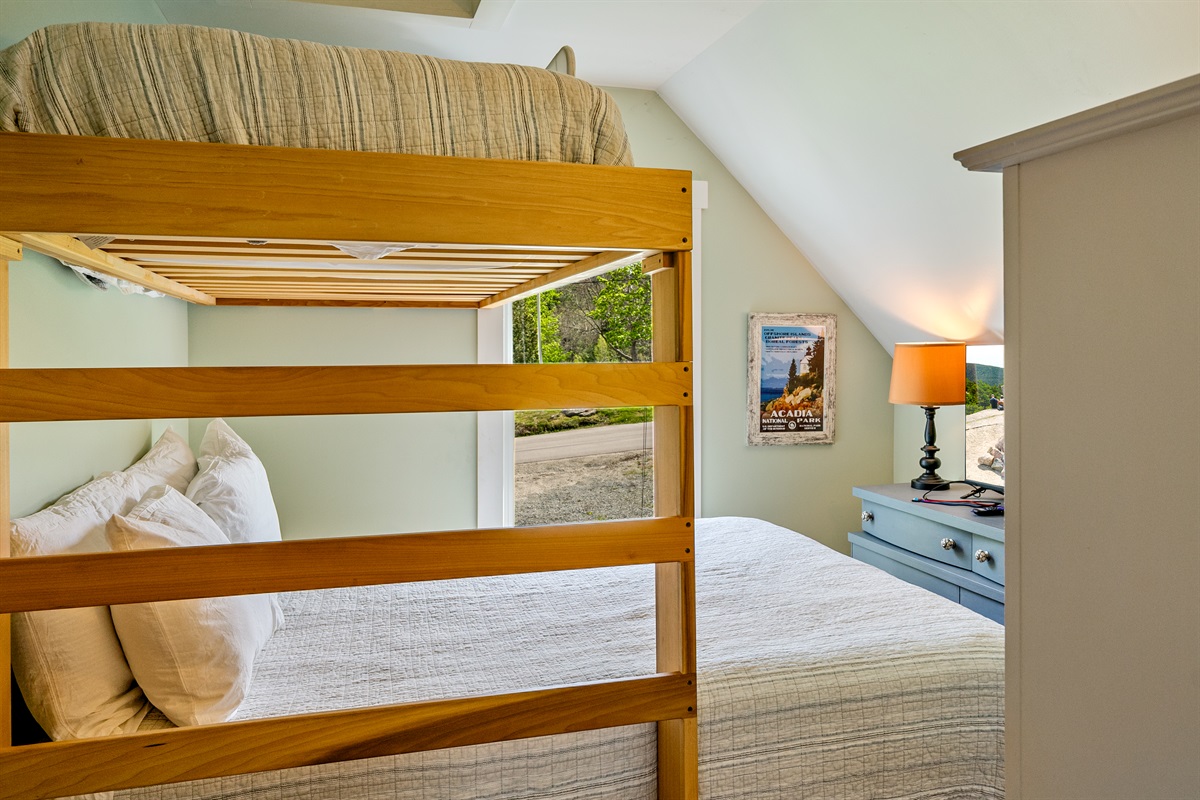 Versatile family sleeping quarters. This bedroom features a twin-over-queen bunk and a new private Roku TV—perfect for late-night movies. A curated antique dresser adds 1880s charm to this active Quiet Side basecamp in historic Hall Quarry.