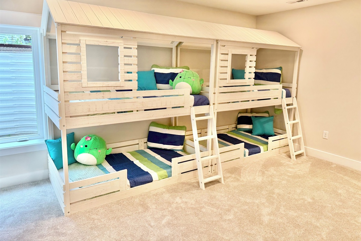 This charming quad bunk room features, crisp white bunks with bright colorful quilts, a play kitchen, Legos, books and toys make it a kids paradise! A built-in play-house coming Winter 2025 will add even more fun to this cheerful imaginative retreat