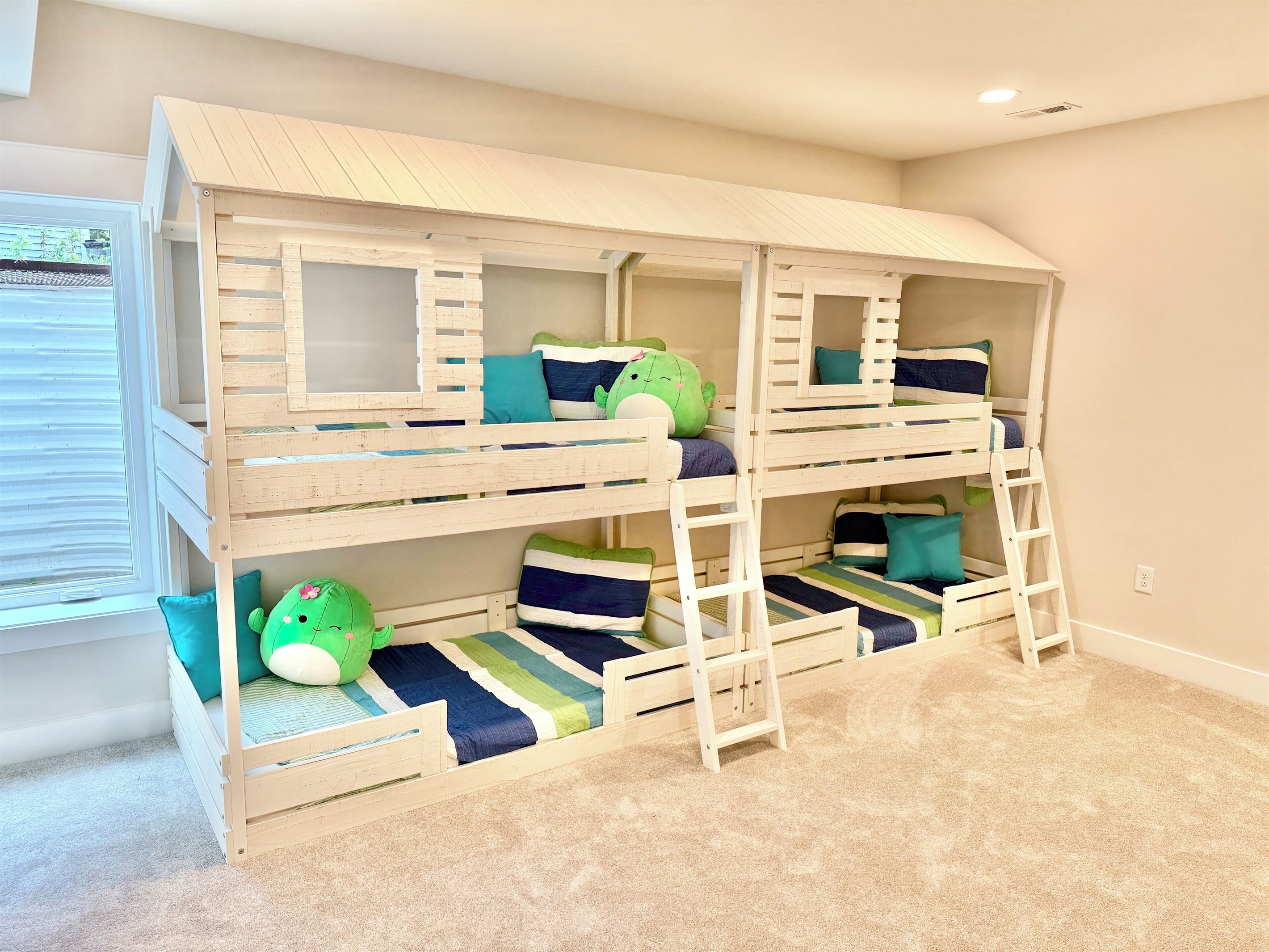 This charming quad bunk room features, crisp white bunks with bright colorful quilts, a play kitchen, Legos, books and toys make it a kids paradise! A built-in play-house coming Winter 2025 will add even more fun to this cheerful imaginative retreat