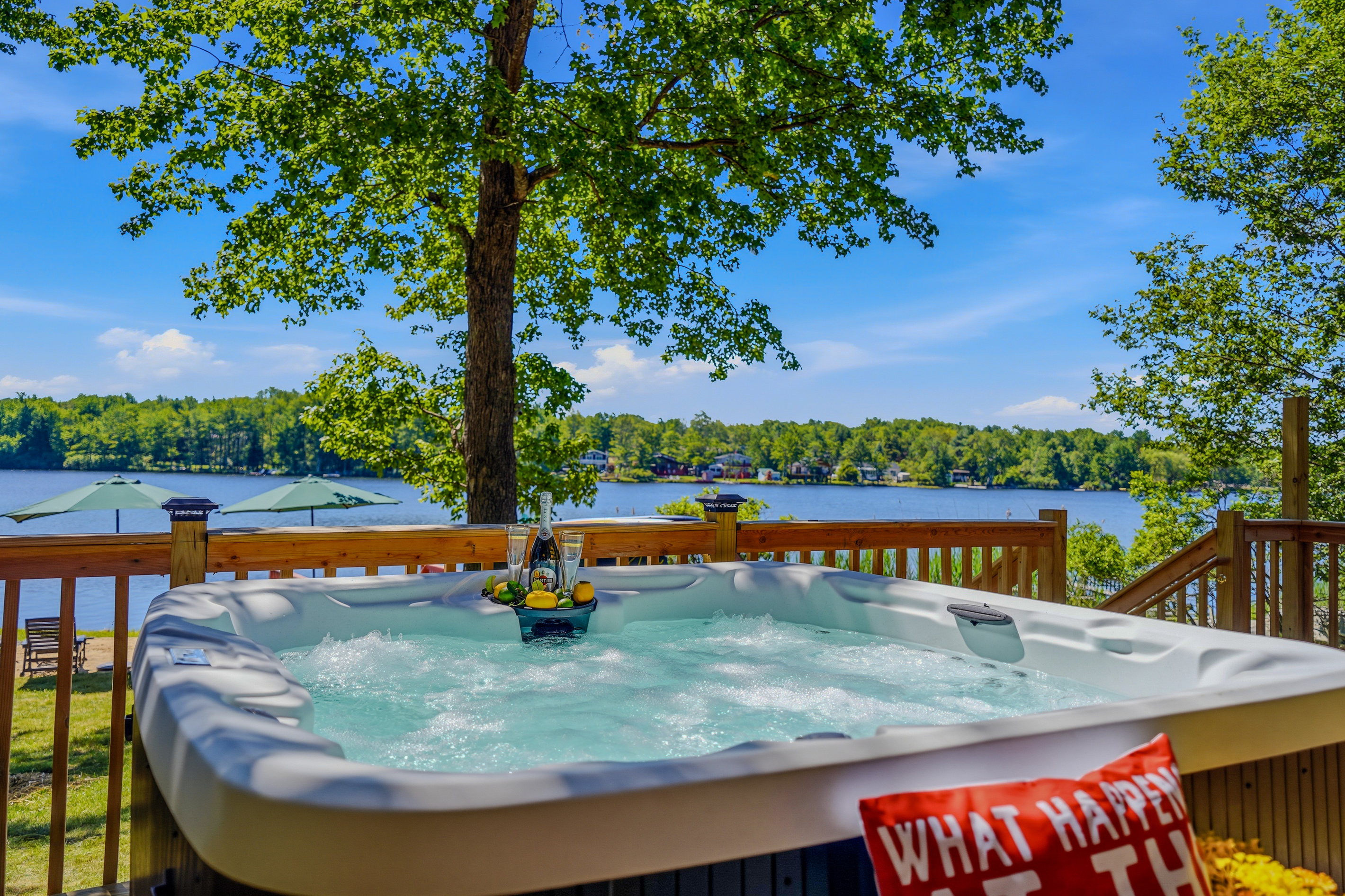 Hot tub with open lake views and tree canopy overhead — day or night, it delivers