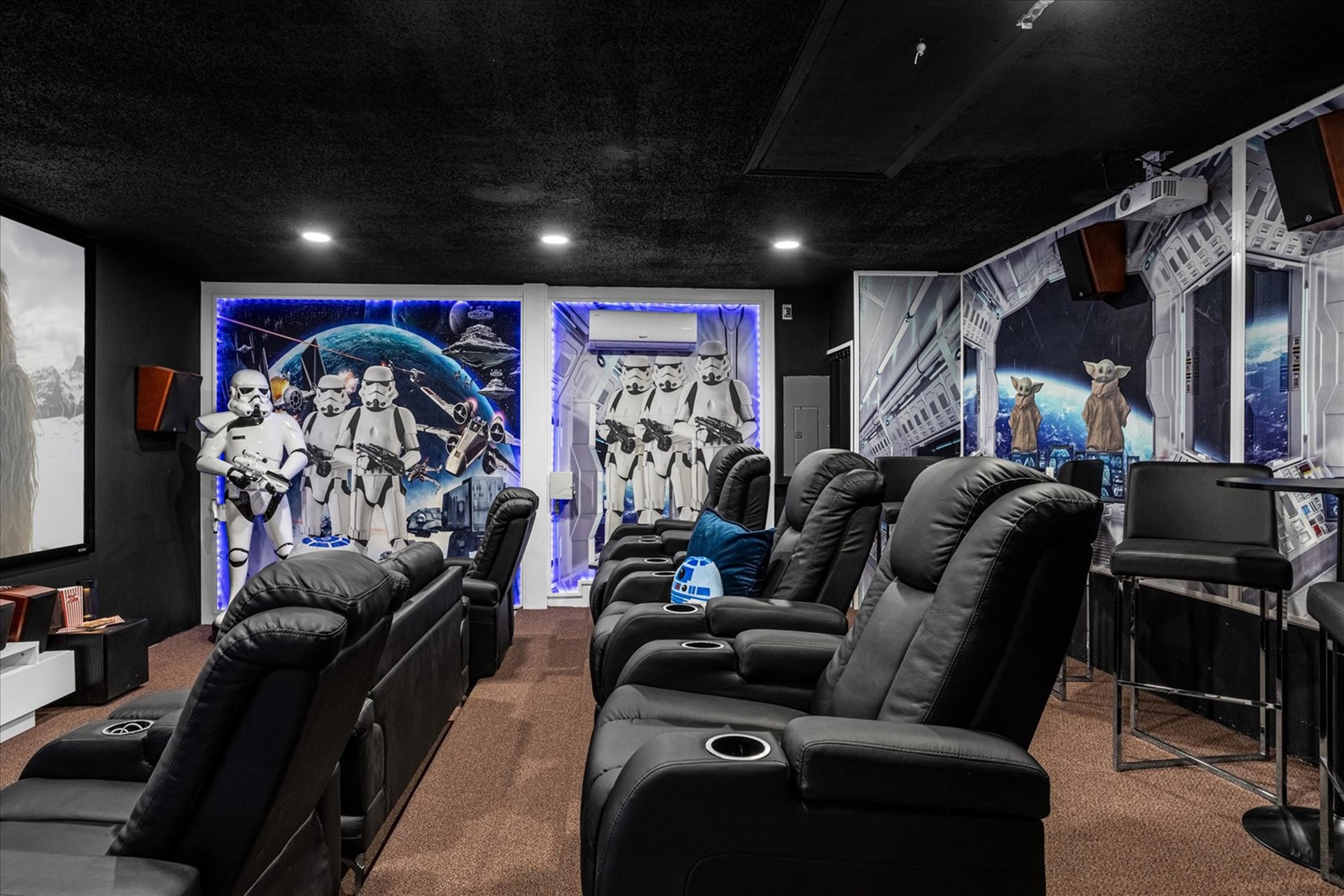 Home theater with reclining leather seats and star wars-themed wall art