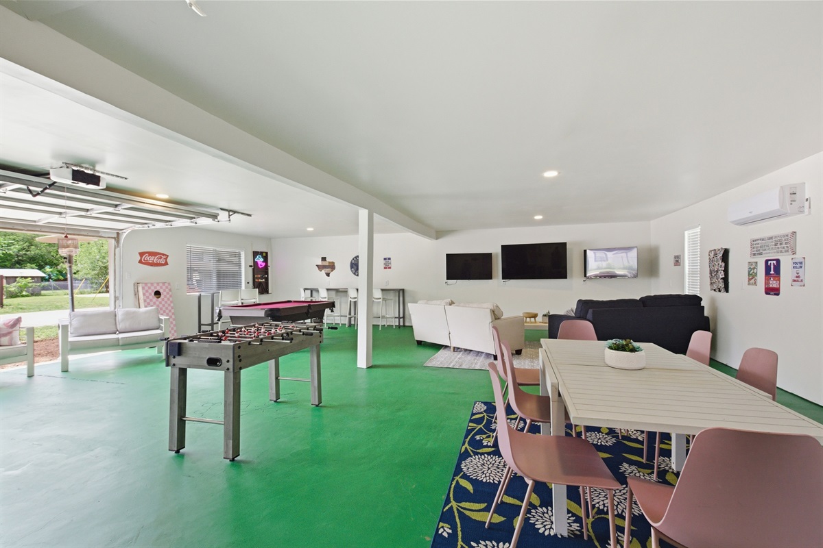 Full Game Room overview with Foosball Table, dining area, and dual 60" Smart TVs. 10-min walk to AT&T Stadium and 15-min walk to Globe Life Field.