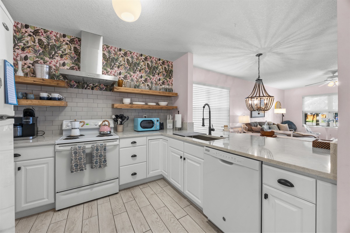 Open‑concept updated kitchen and living space with floating shelves and a bright coastal vibe.

