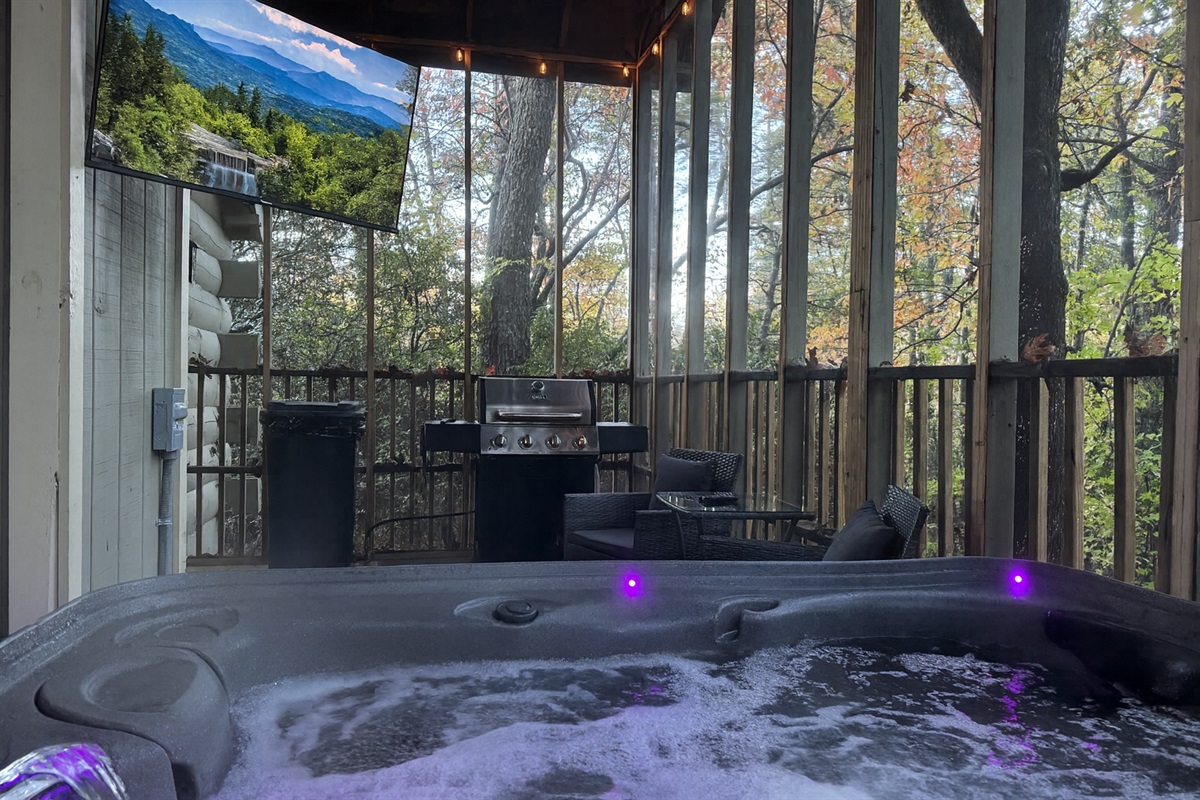 Private hot tub with forest views, outdoor seating, and grill for relaxing nights.