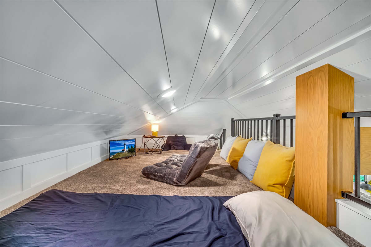 Newly finished loft with gaming area (just bring your own game machine to use with the TV provided), 2 adjustable chairs, 2 floor mattresses, extra lounge pillows & games. Only accessible by ladder, ceiling not high enough for an adult to stand up fully.