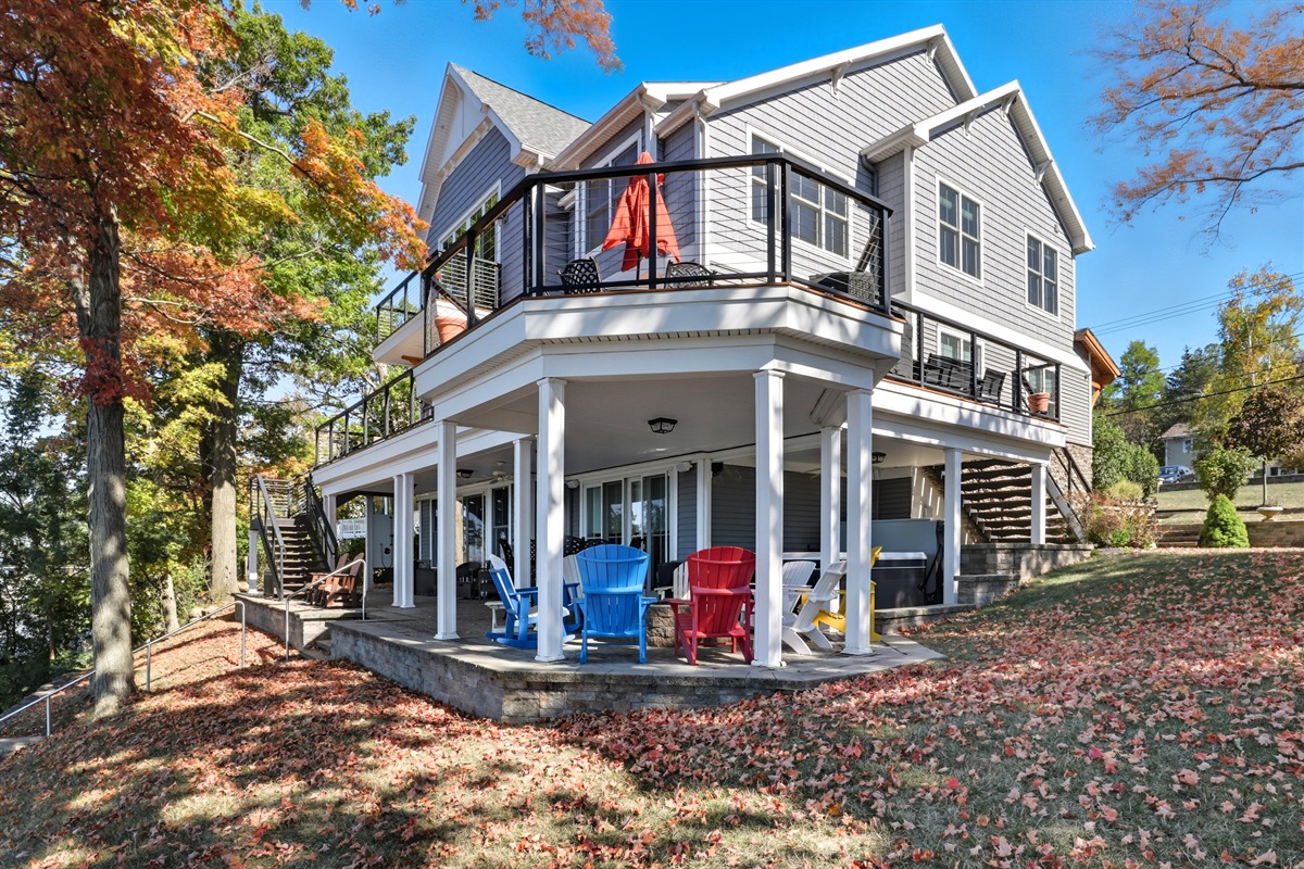 Charming exterior with wraparound porch and classic lake style.