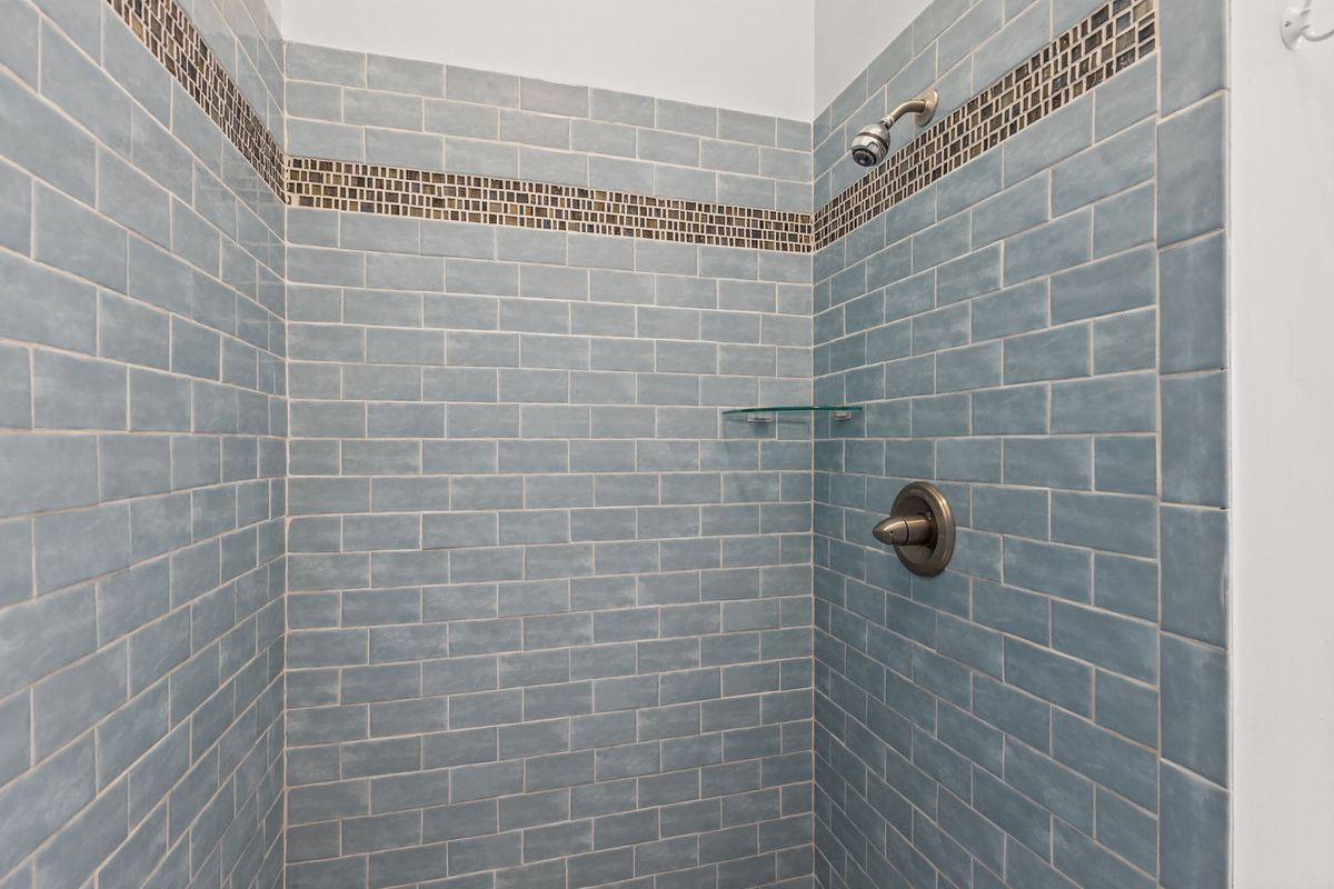 Refresh in the beautifully tiled walk-in shower, a peaceful retreat after sun-soaked adventures along the Crystal Coast
