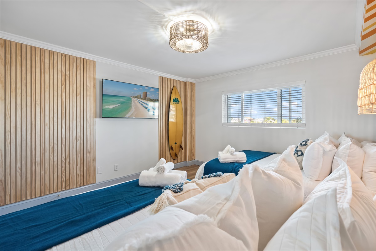Wooden accent walls and a surfboard add to the coastal design.