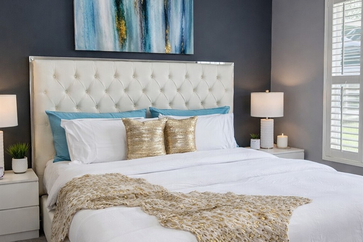 Modern bedroom with a tufted headboard and abstract wall art