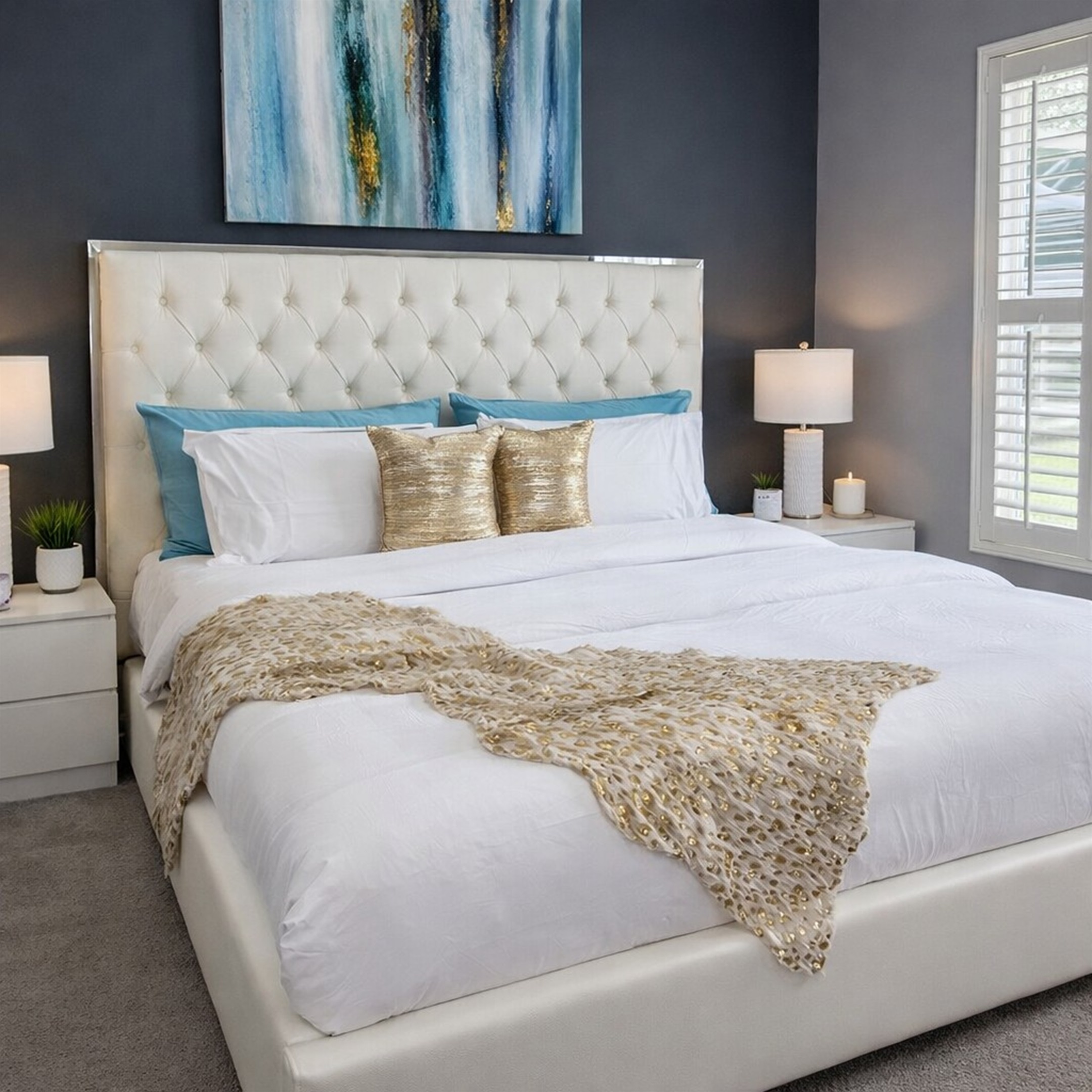 Modern bedroom with a tufted headboard and abstract wall art