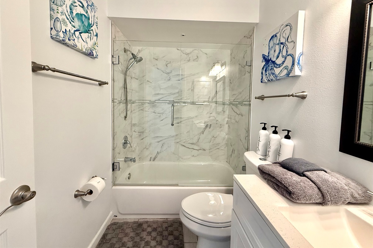 Enjoy a hotel-like experience with modern lighting, glass enclosure, and a spacious vanity.