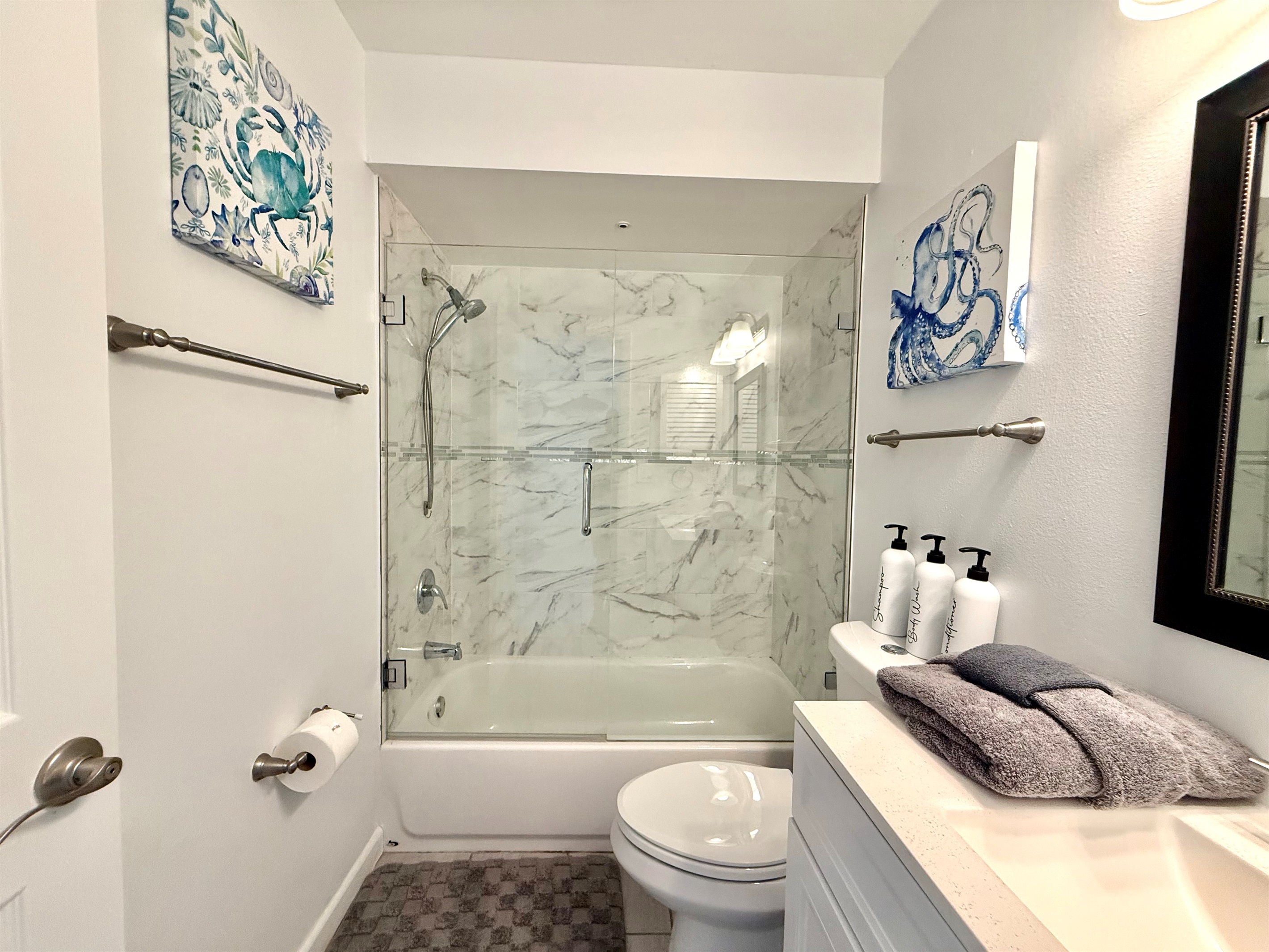 Enjoy a hotel-like experience with modern lighting, glass enclosure, and a spacious vanity.