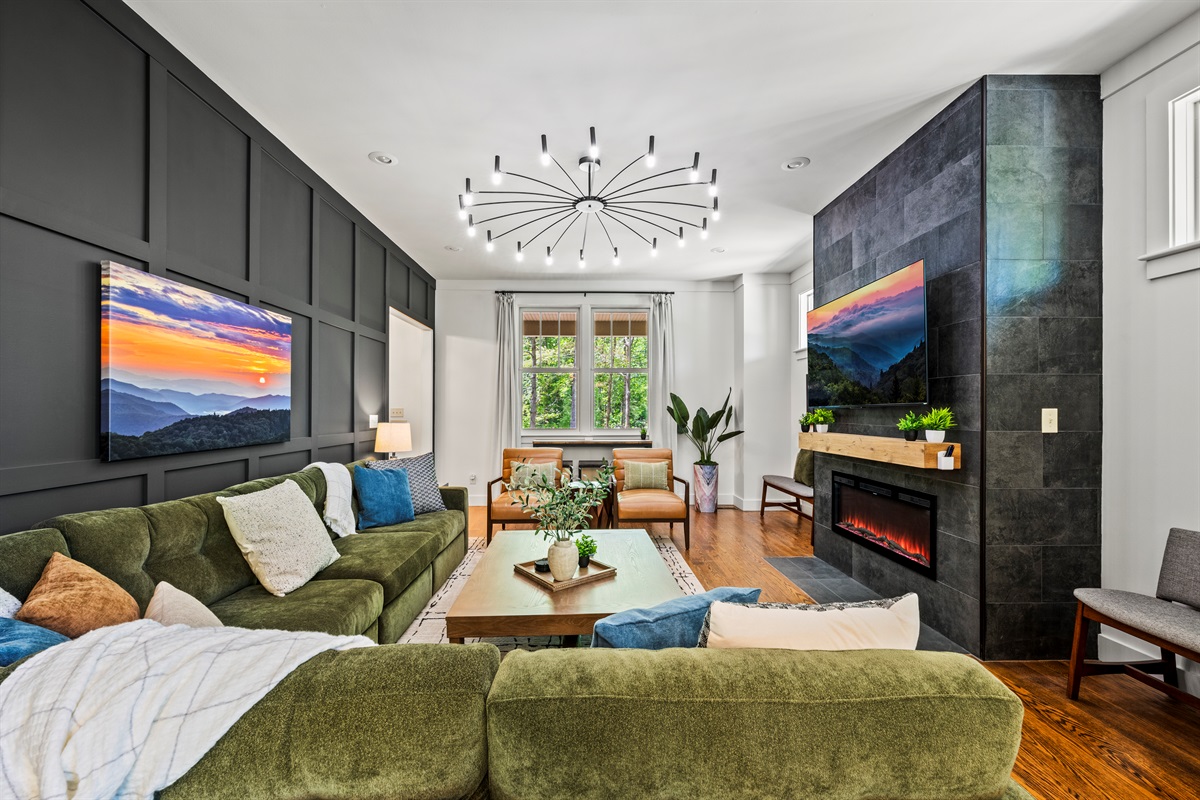 Gather around the floor-to-ceiling fireplace in this stylish living room with 10-foot ceilings, warm wood tones, and locally sourced photography. The oversized sectional is perfect for movie nights or relaxed conversation.