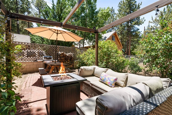 The patio features a sectional, propane firepit, picnic table, umbrella and propane BBQ