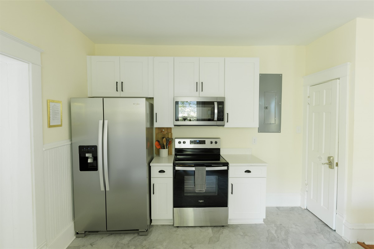 Stove, microwave, refrigerator, and cooking essentials.
