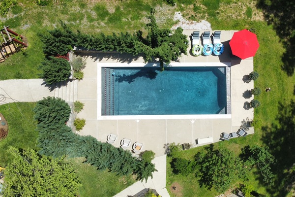 Aerial view of pool in forest setting.