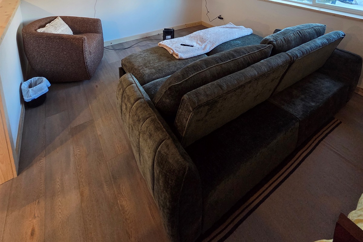 Loft living area includes large swivel chair, sofa sleeper, and big screen TV.