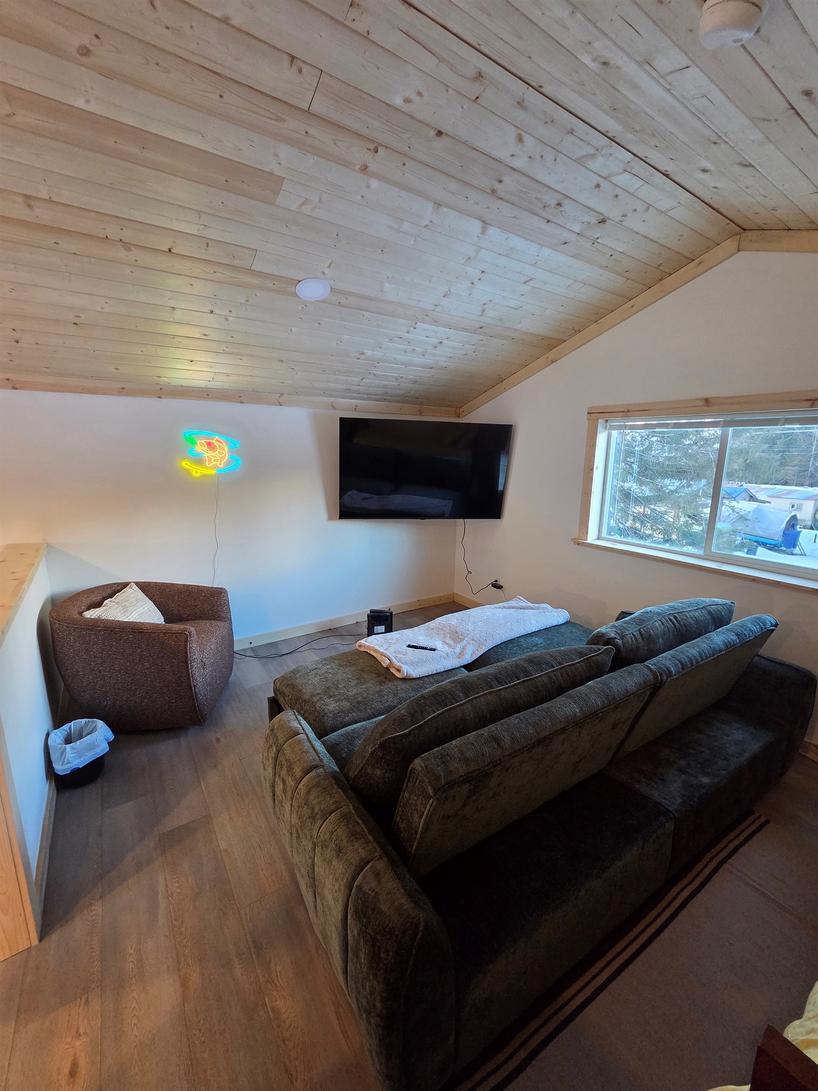 Loft living area includes large swivel chair, sofa sleeper, and big screen TV.