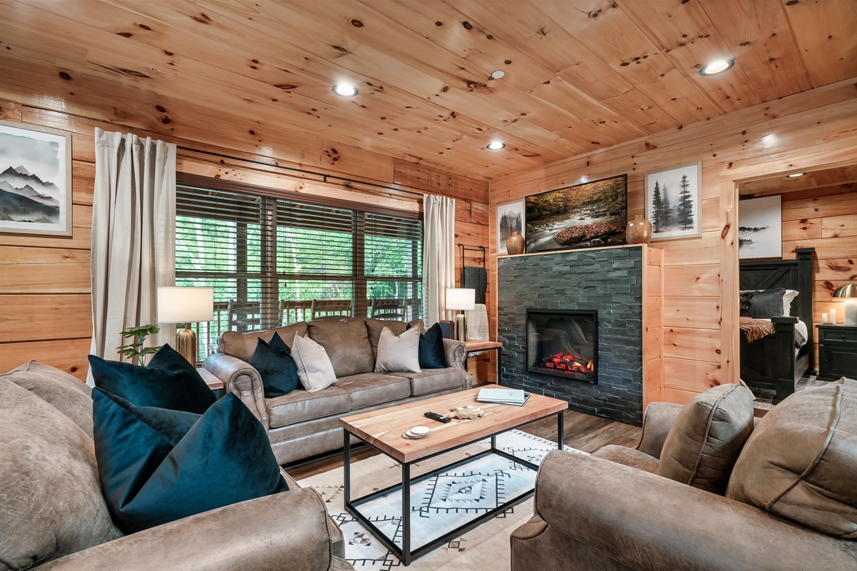 Living room with electric fire place, smart TV and comfortable seating.