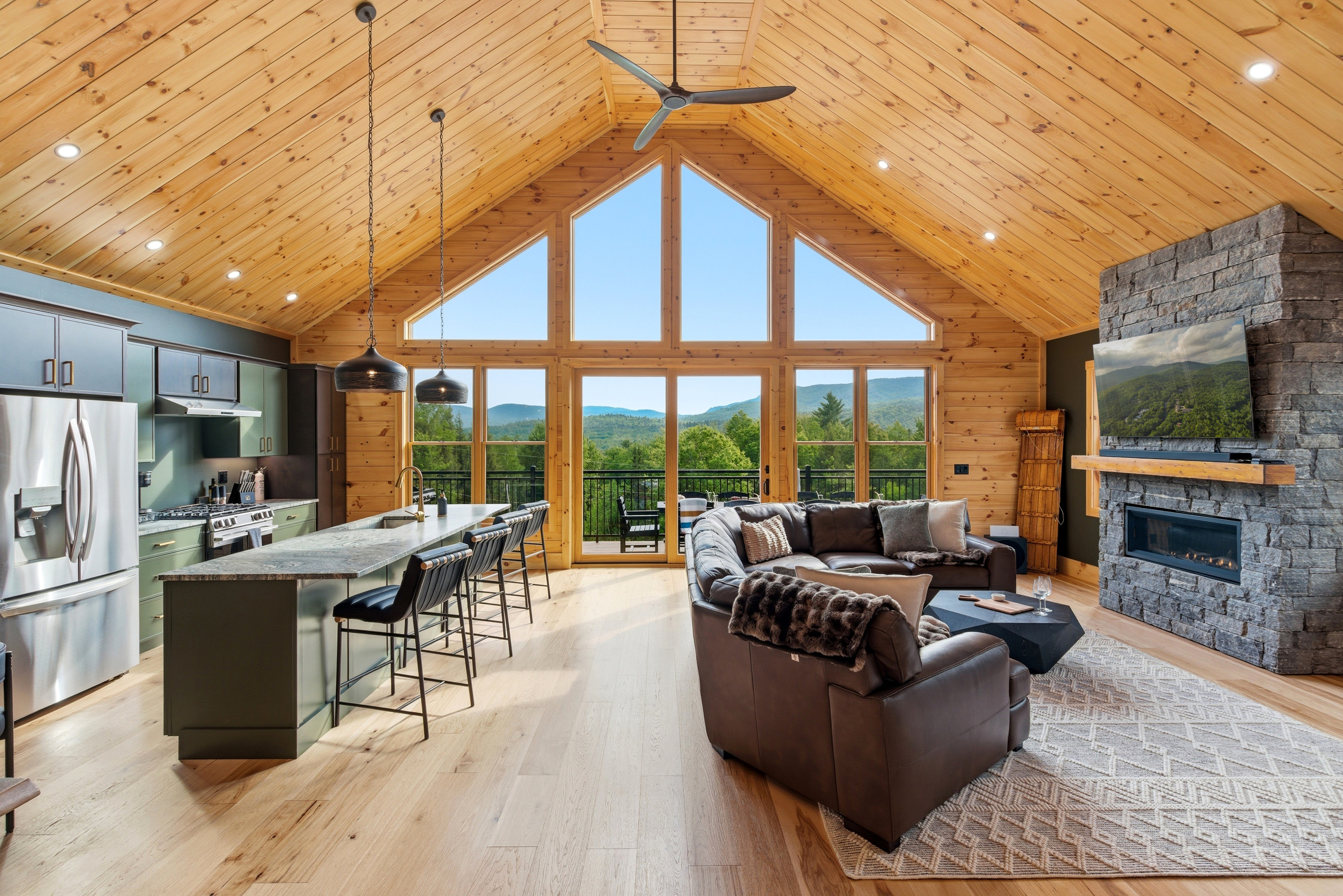Enjoy an airy open-concept layout connecting the kitchen, dining, and living spaces beneath vaulted wood ceilings.