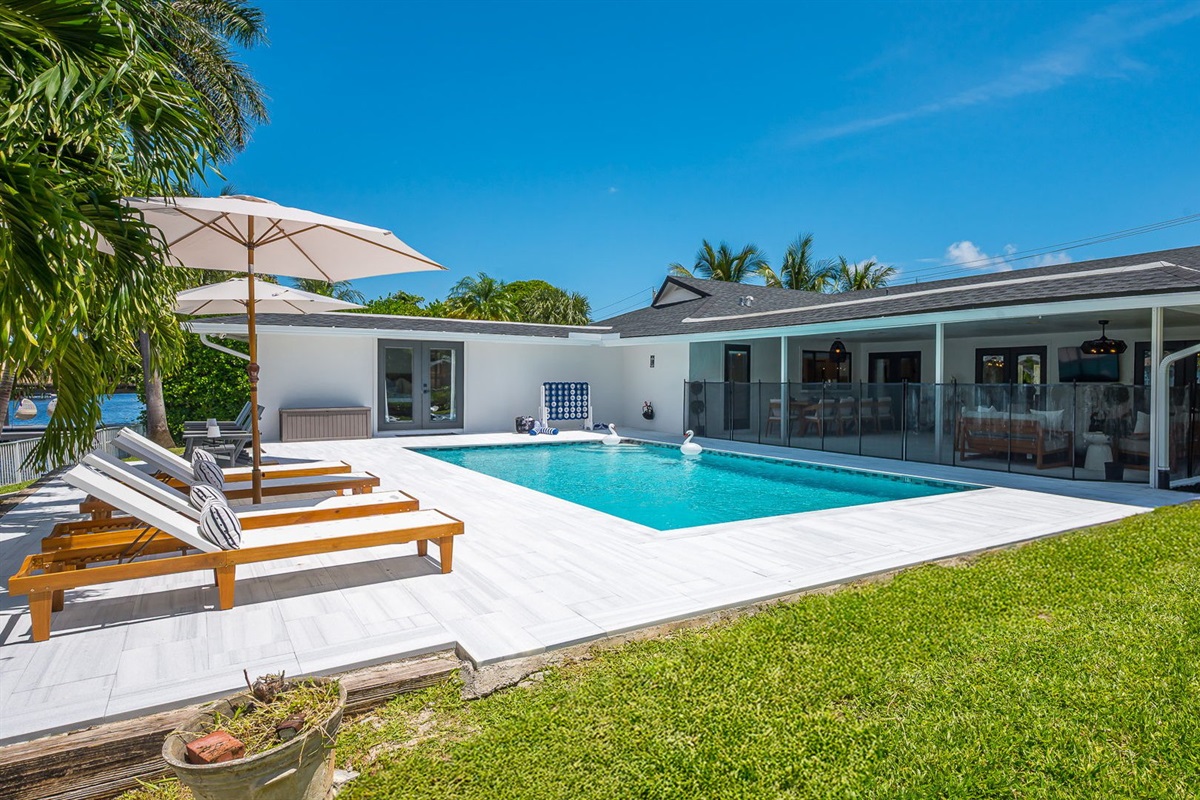 Spend your days lounging by the shimmering pool, dining al fresco under the covered patio, and unwinding in stylish outdoor living spaces—all set against a serene lakefront backdrop with private dock access