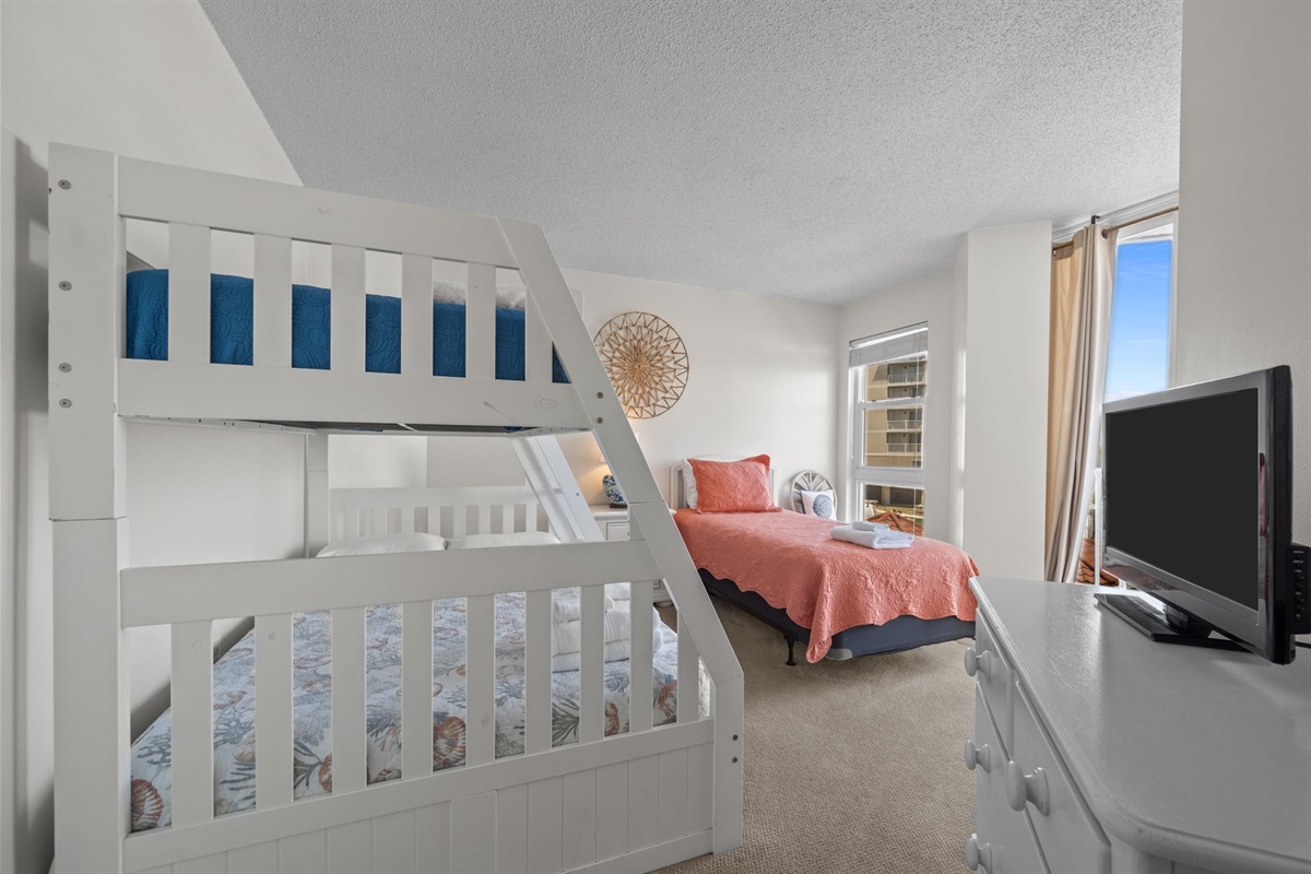 Versatile 2nd bedroom with bunk setup and additional bed for flexible sleeping arrangements