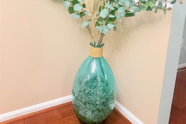 A decorative vase with greenery adds a fresh, peaceful element to this thoughtfully styled corner.  