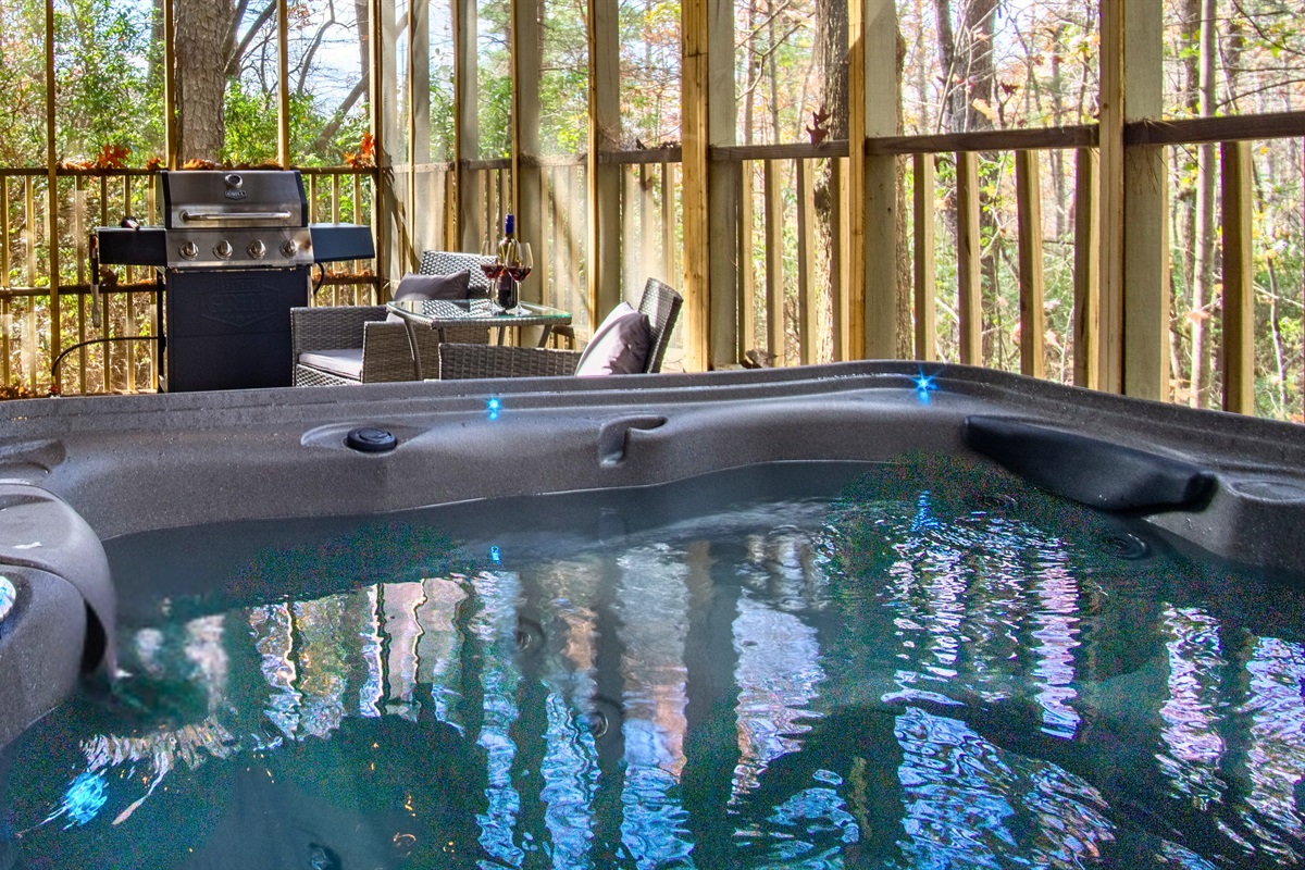 Private hot tub with forest views, outdoor seating, and grill for relaxing nights.