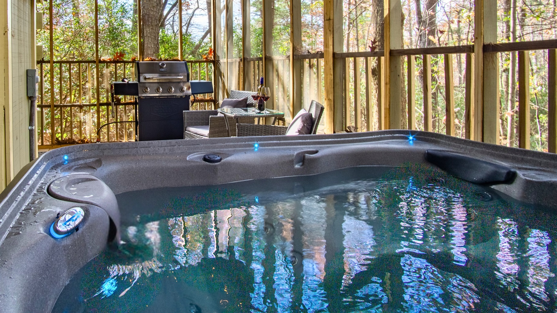 Private hot tub with forest views, outdoor seating, and grill for relaxing nights.